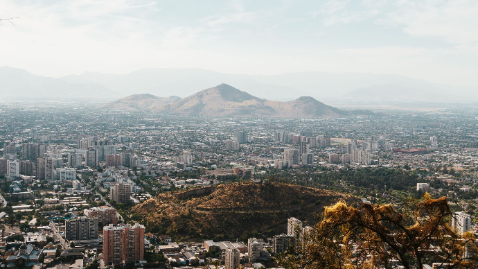 Vue aérienne de Santiago, Chili avec des montagnes en arrière-plan et le paysage urbain en dessous.